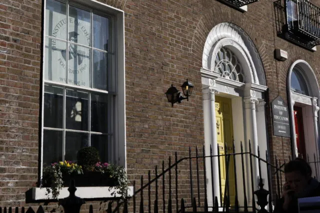The Institute of Education's Georgian entrance on Leeson Street, with a yellow front door framed by white columns and a fanlight window, and "The Institute of Education" sign to the right