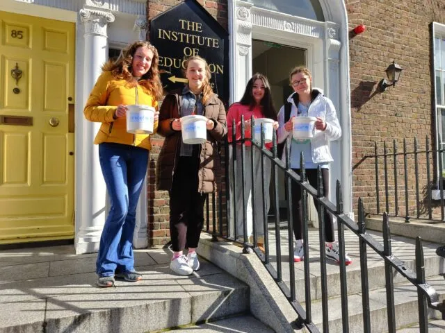 Students holding the fundraiser buckets