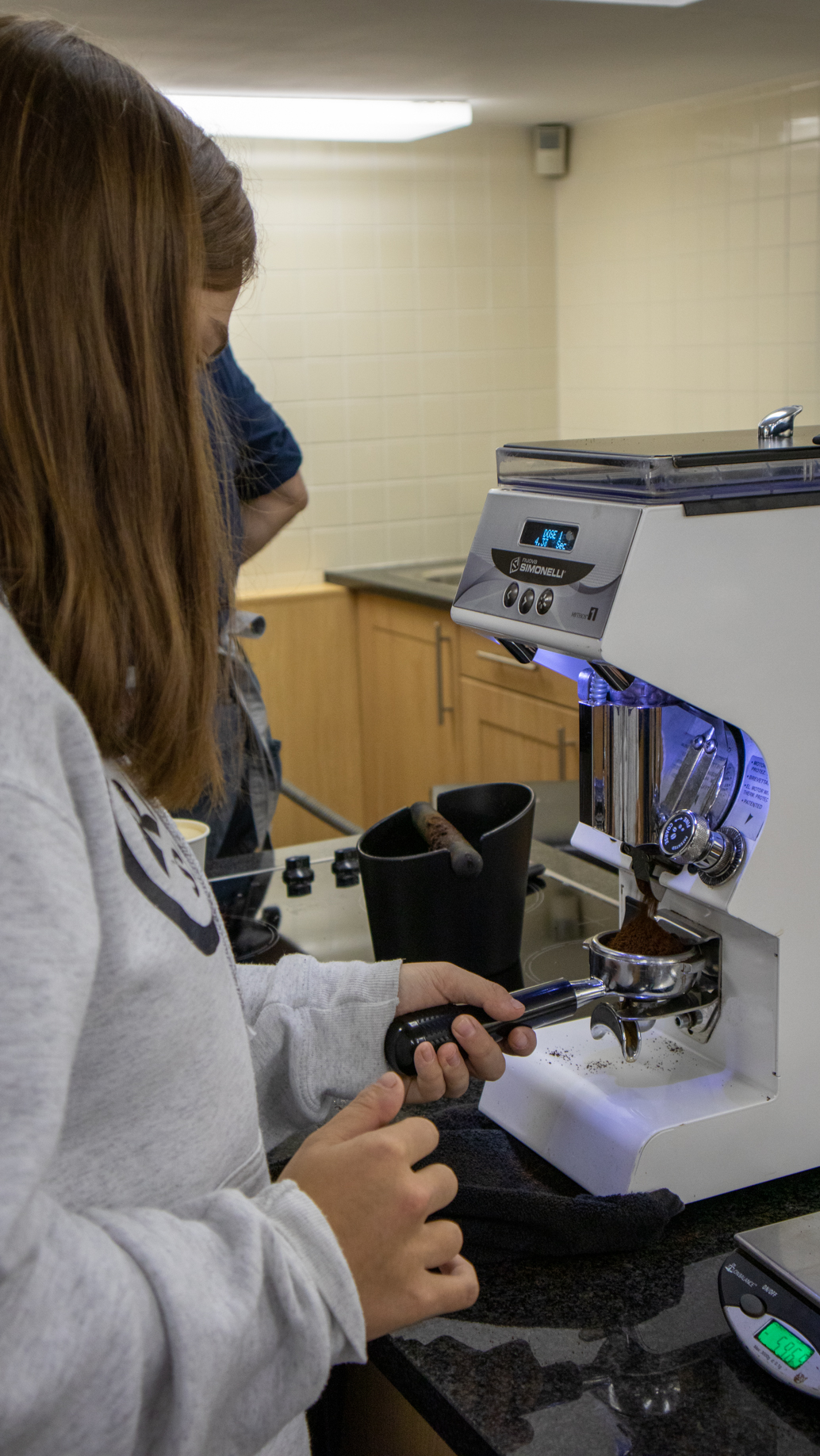 Student learning to use coffee machine