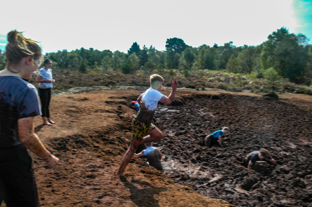 Students jumping into mud