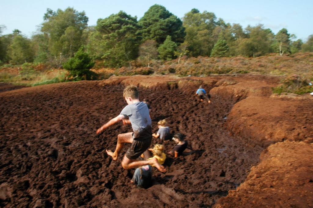 Students jumping into mud