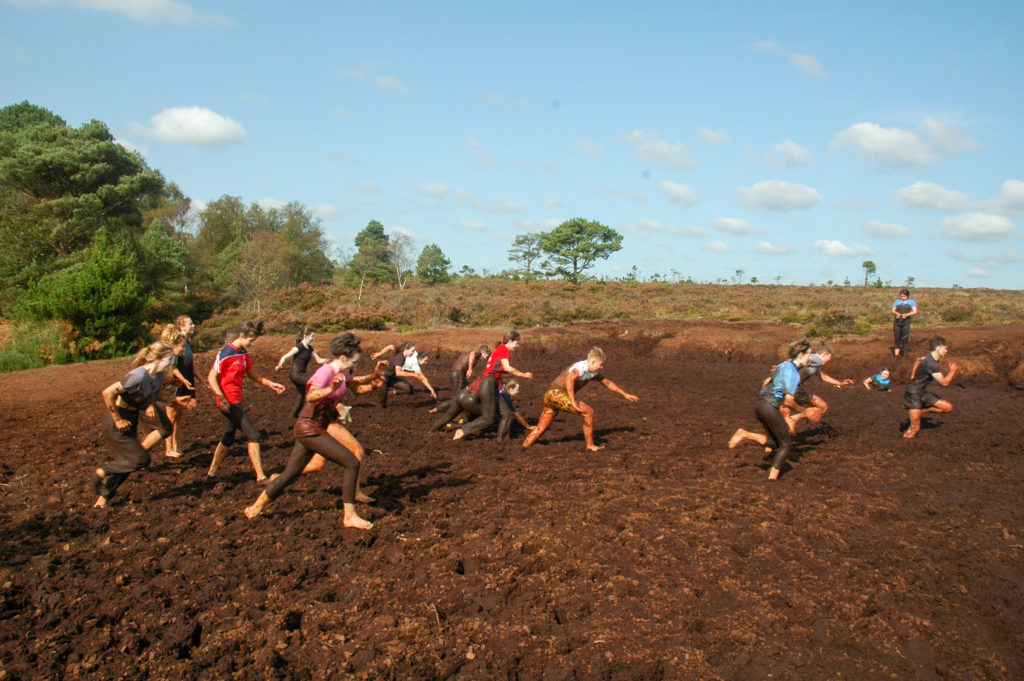 Students jumping into mud