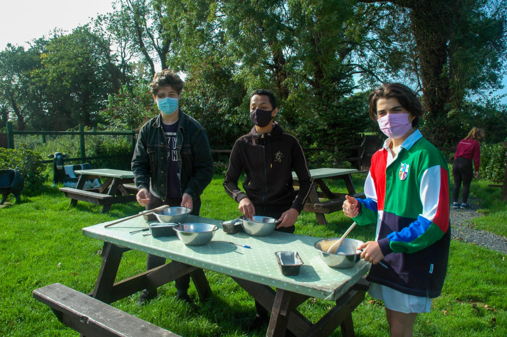 Students outside baking on bench
