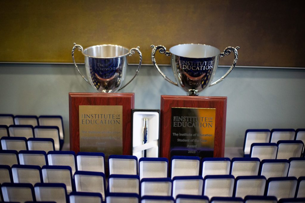 Photo of two plaques, trophies and the opened medal boxes