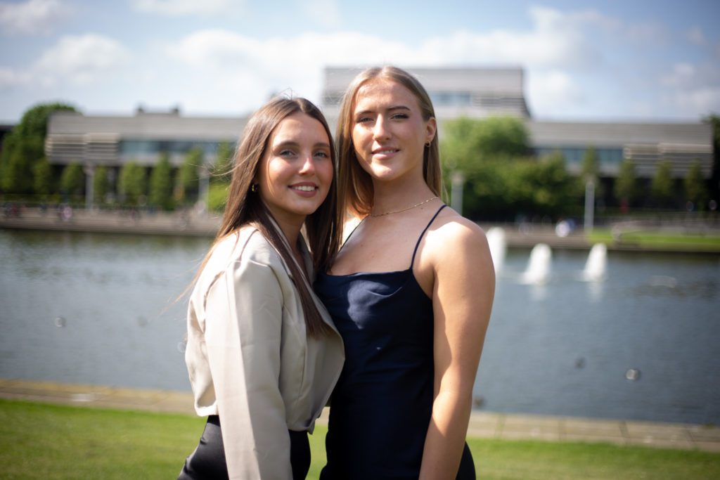 Two women posing for photo, side by side