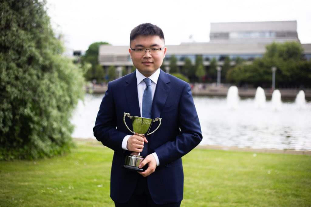 Man posing with trophy