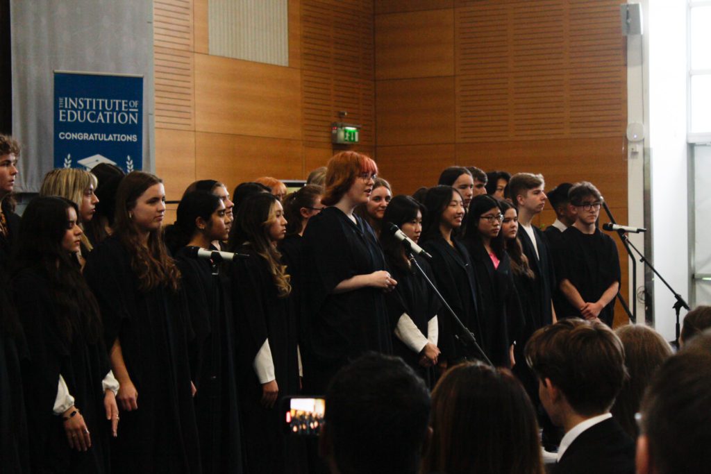 Large Group of graduates, with 3 microphones aimed at them
