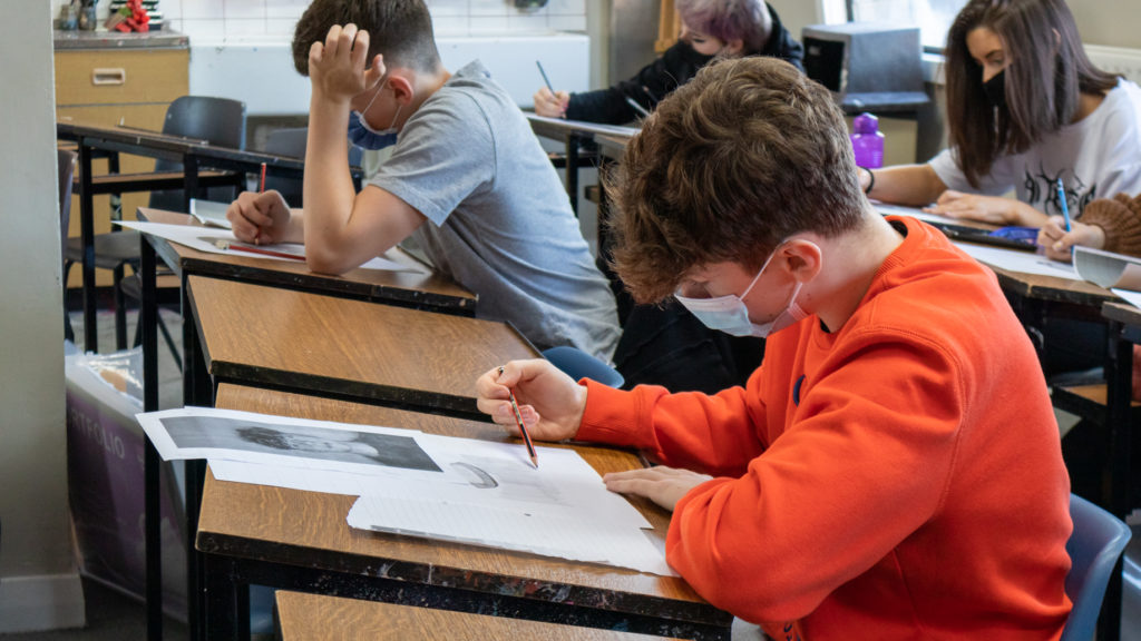 Student drawing his self portrait