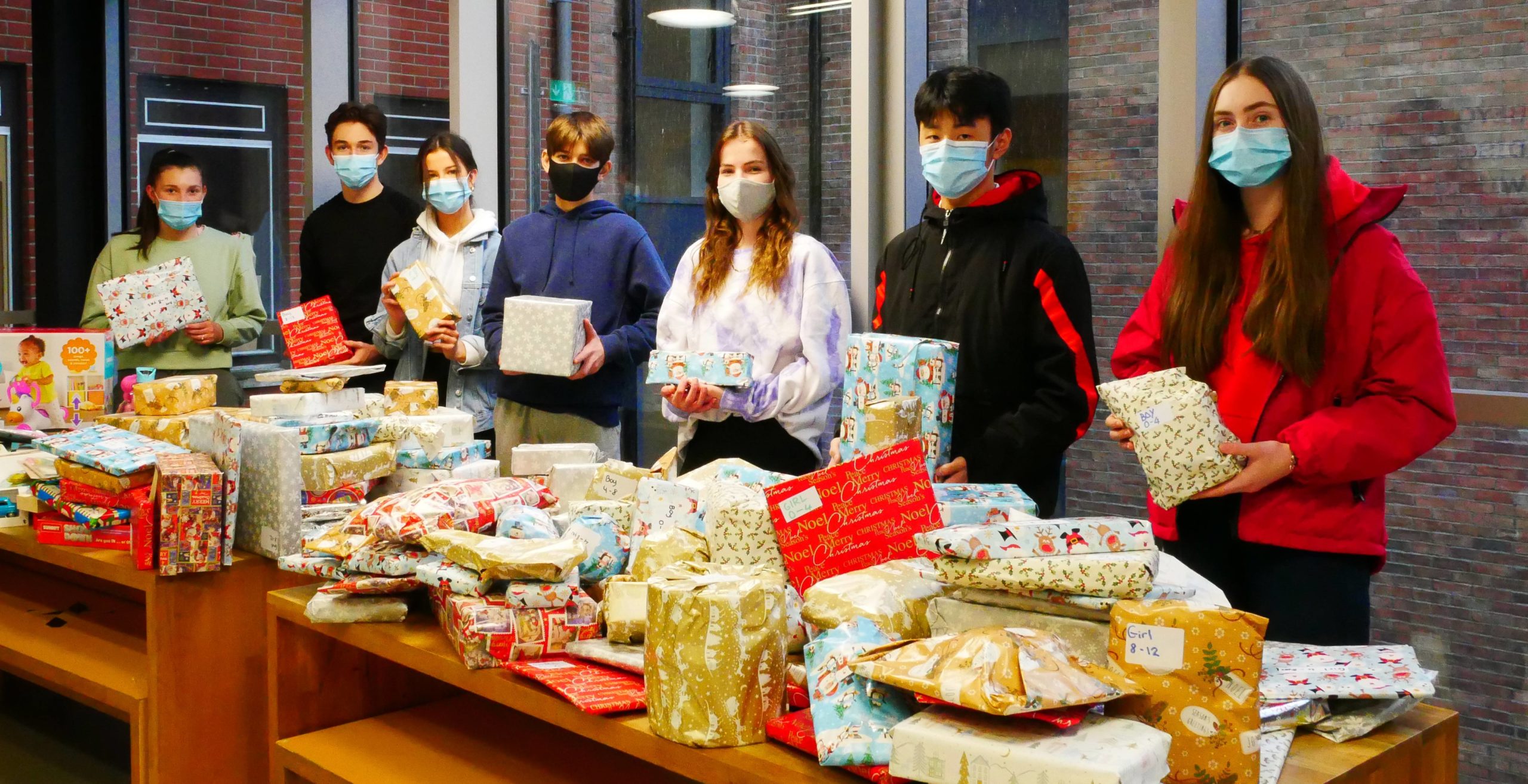 Students and their teacher taking photos with the Christmas Gifts