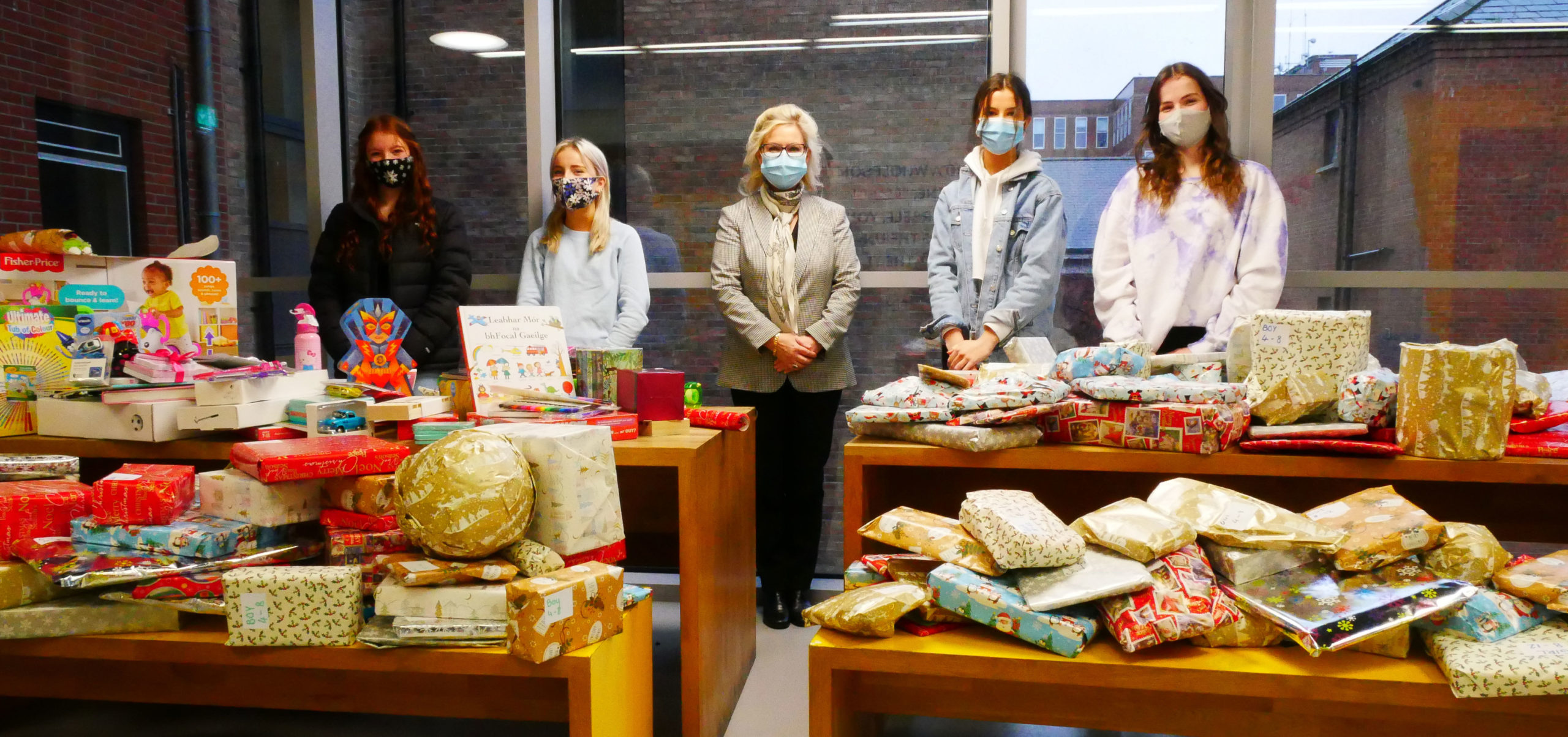 Students and their teacher taking photos with the Christmas Gifts