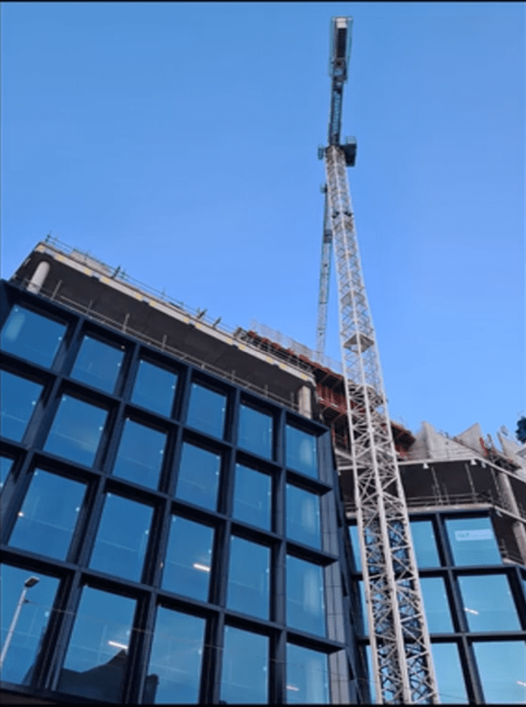 Photo of a crane in front of a unfinished building
