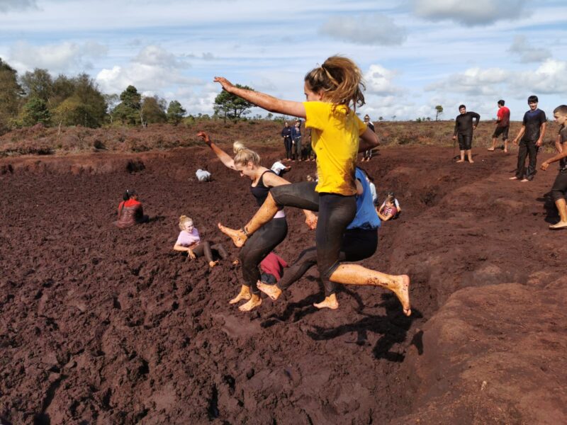 Students leaping into the mud