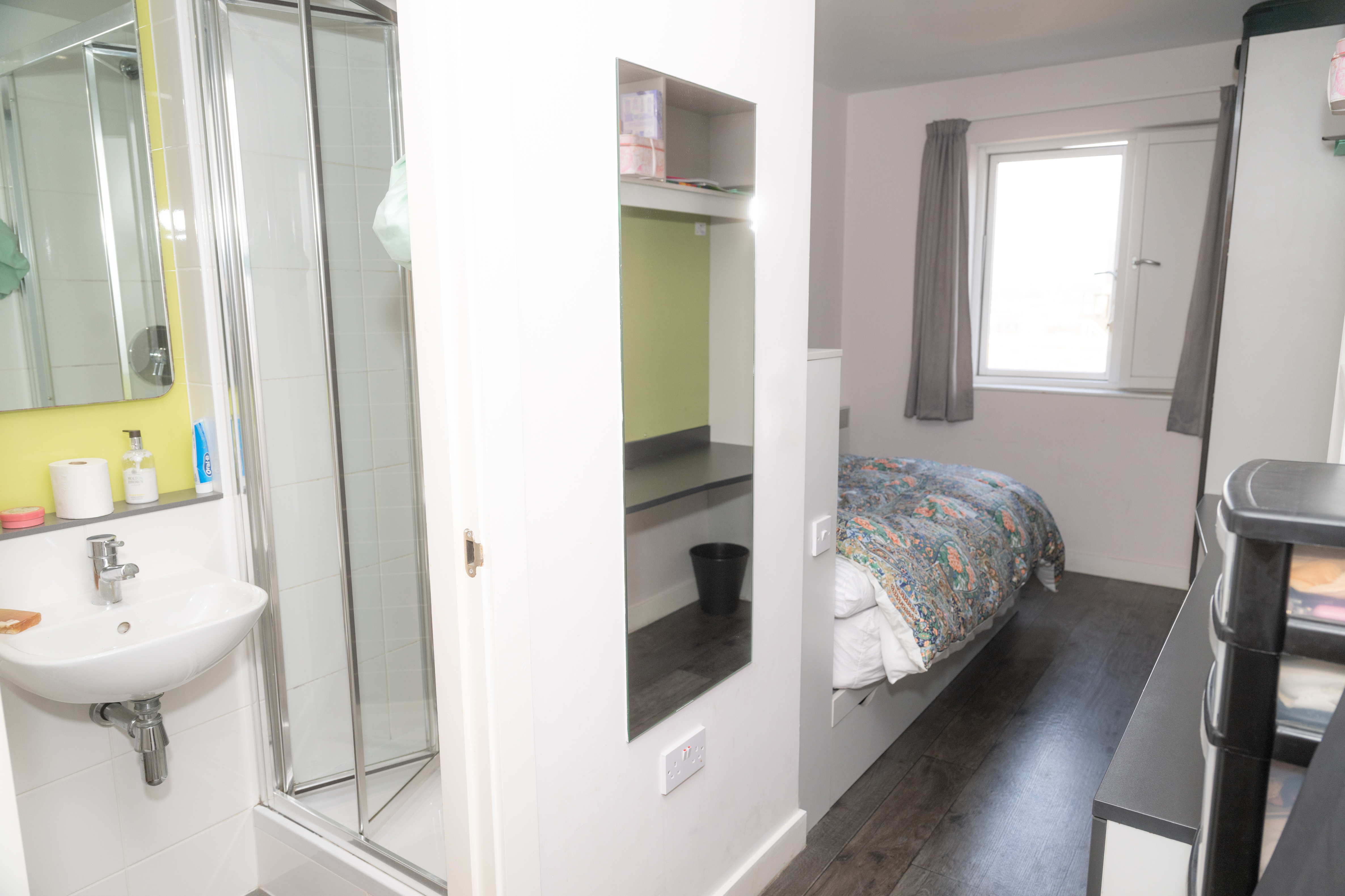 Bedroom: Single bed with green headboard, built-in shelving and desk unit.