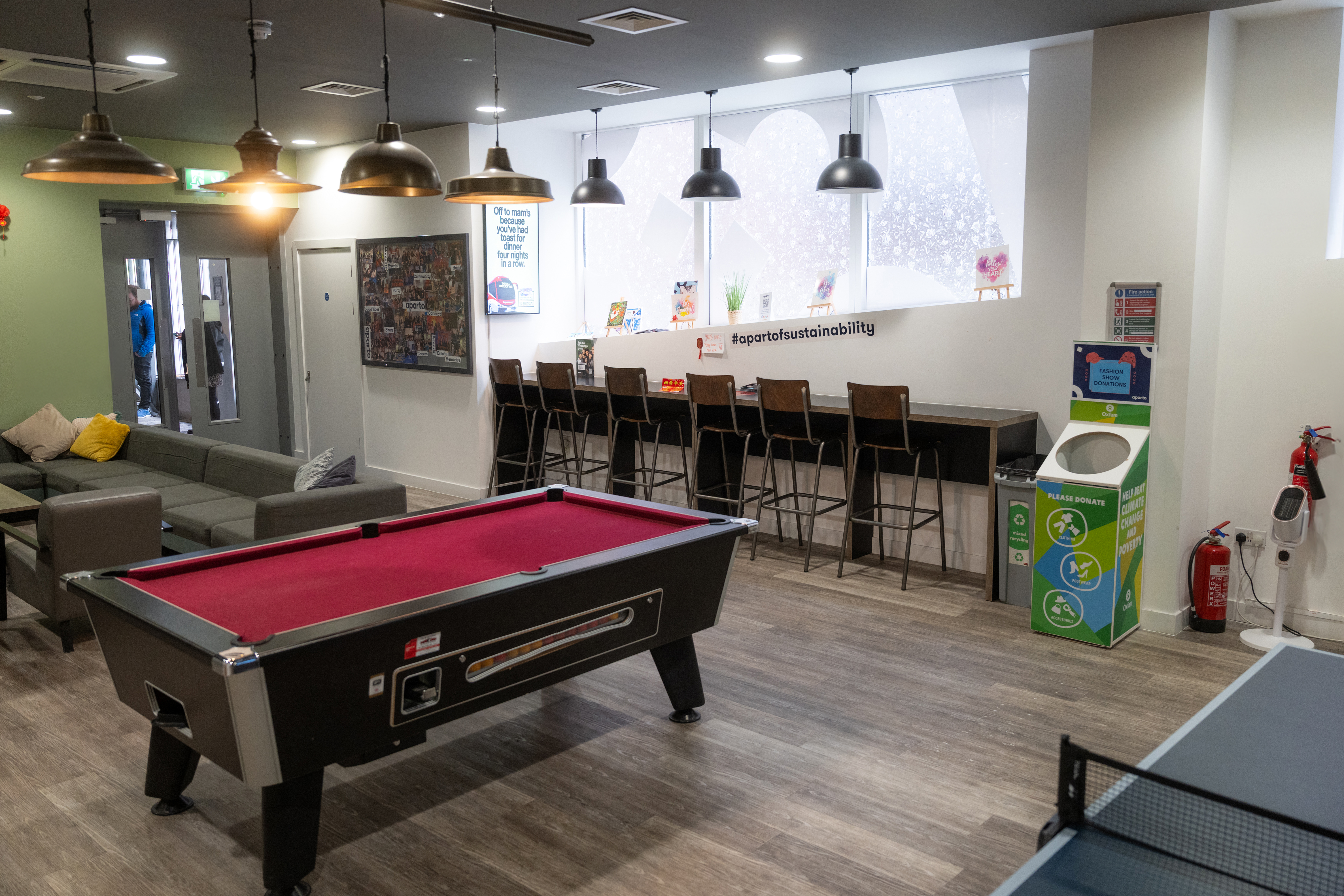 Pool table / games room: Common area with a red pool table, arcade machine and brick feature wall.