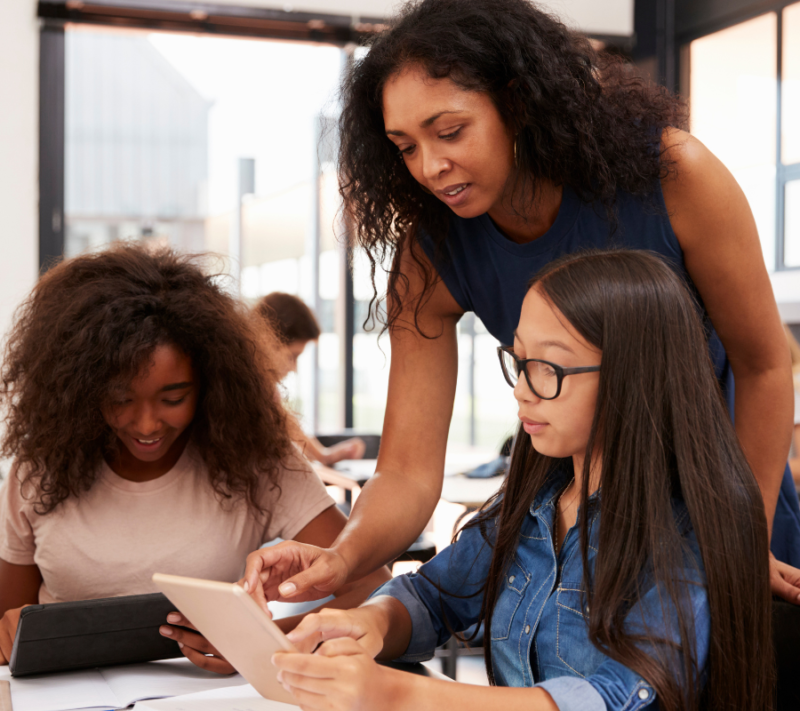 Teacher helping students at their desks