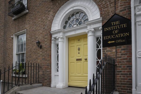 The Institute of Education's Georgian entrance on Leeson Street, with a yellow front door framed by white columns and a fanlight window, and "The Institute of Education" sign to the right.